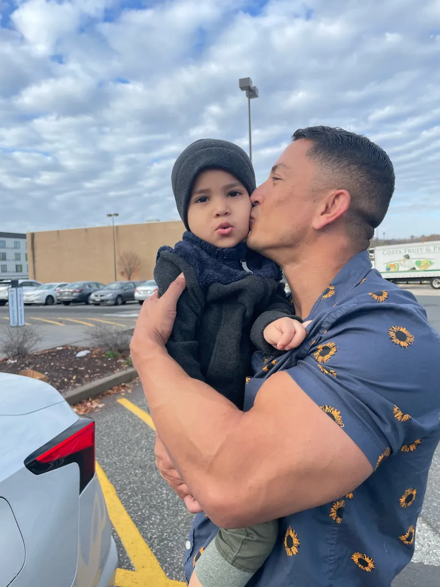 Patrick kissing his toddler son on the cheek